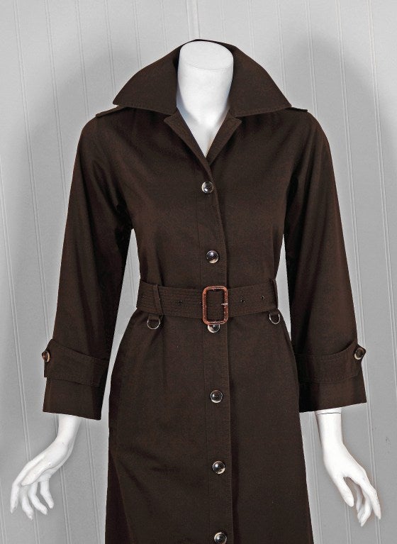 Chic chocolate brown belted cotton-twill trench jacket from the infamous Rive Gauche collection during the mid-1970's. Pieces from this decade are very rare and are true examples of fashion history. I adore the shoulder epaulets and tortoise