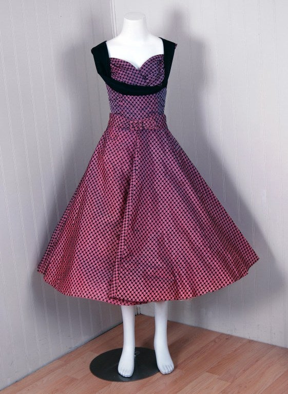 Breathtaking 1950's party dress fashioned from sparkling glitter flocked-taffeta. This garment is so fresh and modern with its vibrant iridescent pink-purple coloring and flirtatious design! This beauty combines a fetching, girlish appeal with a