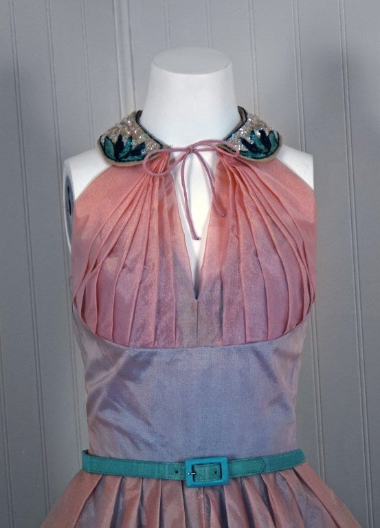 This is one of the most alluring and flattering 1950's party dress I have ever seen. Fashioned from iridescent baby-blue & pink silk-organza, this creation has everything a woman wants. The bodice is a beautiful sequin-beaded collar, low-cut plunge,