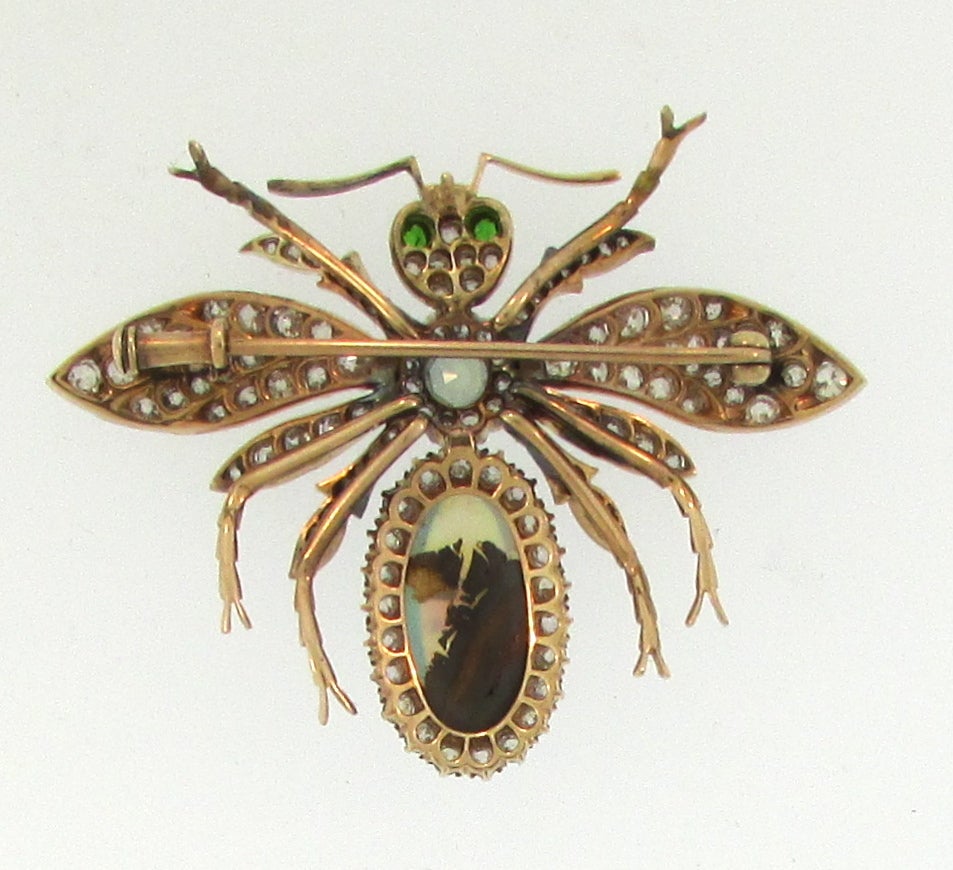 Wonderful example of late-Victorian naturalistic jewelry. This moth brooch is set with diamonds, emeralds, a large opal, and and aquamarine in the centre.