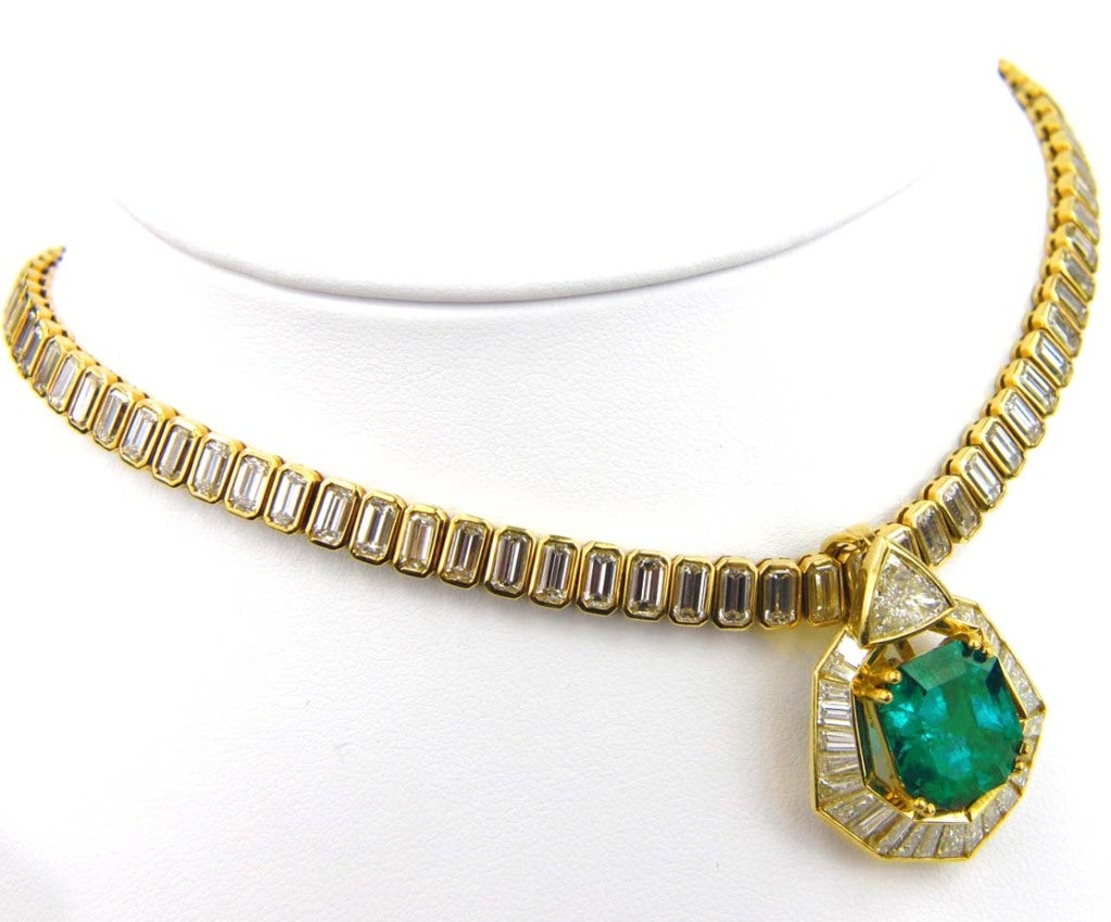 This is a beautiful Yellow Gold Necklace with a center Emerald stone weighing 8.90 carats and Diamonds set through the chain of the necklace and around the center stone. The diamonds weight is 25 carats having an H color and VS clarity. The total