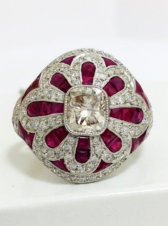 Magnificent  cocktail ring, with one square ideal cut diamond, of L si1, 1.20 carat
And 95 old mine cut diamonds of H si1 totaling 1ct
And 34 natural calibrated rubies, 2.50 cts
Superb detail in the craftsmanship, note details of rubies. Ring is