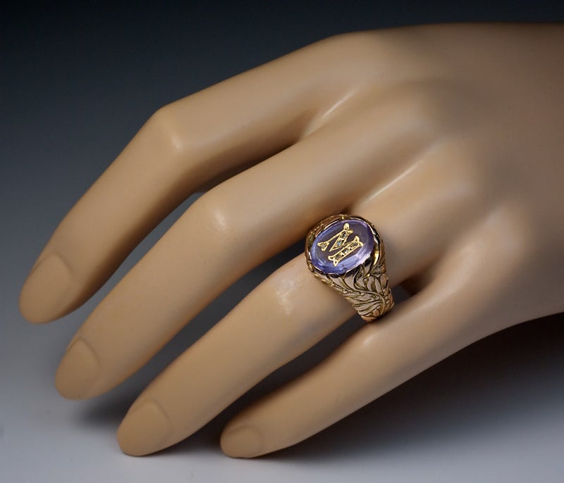 This finely modeled and well crafted vintage Russian gold ring was made in Moscow between 1908 and 1917.

The pale purple oval amethyst is inlaid with a gold monogram 'M', embellished with six tiny rose cut diamonds.

The chased gold shank is