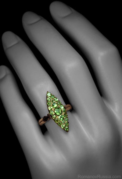 This unusual marquise shaped antique ring can be a unique engagement ring. The ring was made in Moscow between 1899 and 1908. 

It is handcrafted in rose gold and set with 23 round cut sparkling demantoid garnets. The demantoids display needle