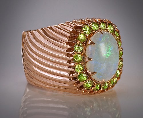 An Unusual Antique Opal and Demantoid Garnet Rose Gold Ring,

made in Kiev between 1899 and 1904.

The wide band of the ring is decorated with parallel swirling grooves, creating a visual motion effect and adding more sparkle.

The ring is