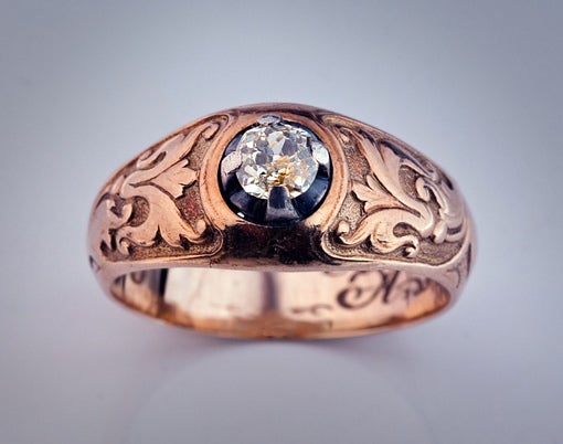 An Antique Art Nouveau Diamond Solitaire Gold Ring.

The 14K rose gold men's ring is decorated with medieval Russian floral designs stylized in Art Nouveau taste.

The ring is centered with an old mine cut yellow diamond in a silver prong