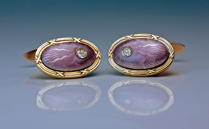 The cufflinks are designed as a pair of oval spherical lilac guilloche enamel plaques set in ribbon-tied reeded gold frames. 

Each is highlighted with an old cut diamond.

Width  - 19 mm (3/4 in.)

Excellent condition.

Marked with 56
