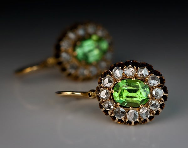 Moscow, circa 1885

The 14K rose gold earrings are centered with two bright apple green oval demantoid garnets from the Russian Ural Mountains, framed by 24 rose cut diamonds.

The demantoids are unusually very clean, what makes them extremely