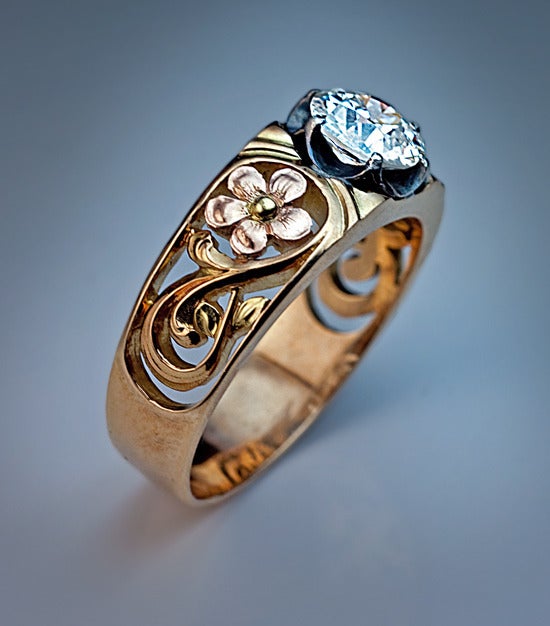 Made in Moscow between 1908 and 1917

A finely modeled gold ring is decorated with openwork Art Nouveau floral designs. It is handcrafted in rose and green 14K gold.

The ring is centered with a sparkling old European cut diamond  6.9 - 7 x 3.95
