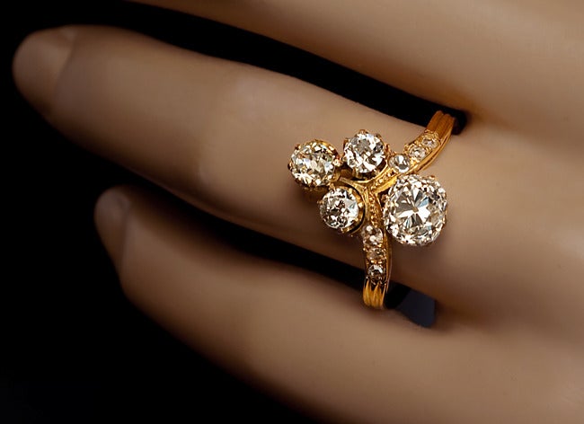 circa 1890

An 18K yellow gold tiara shaped ring is prong set with two antique cushion cut and two old European cut diamonds.

The largest stone is a bright white 1.35 ct cushion cut diamond, G color, VS2 clarity.

The shoulders of the ring