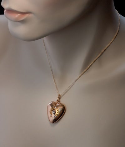 Made in Moscow between 1908 and 1917

A puff heart charm pendant is made of a polished 14K rose gold. The front is applied with a matte yellow gold horse shoe (good luck symbol) and embellished with diamonds.

Height without suspension ring - 31