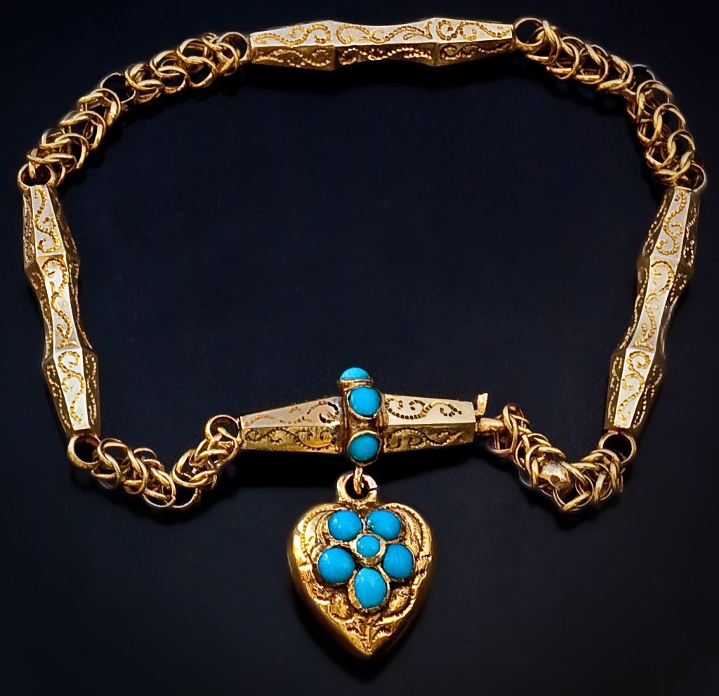 Victorian Era Gold and Turquoise Bracelet 

circa 1860

A 14K gold bracelet with hand engraved links and heart shaped locket charm is embellished with cabochon-cut turquoise. 

The heart charm is fitted with a glazed miniature picture