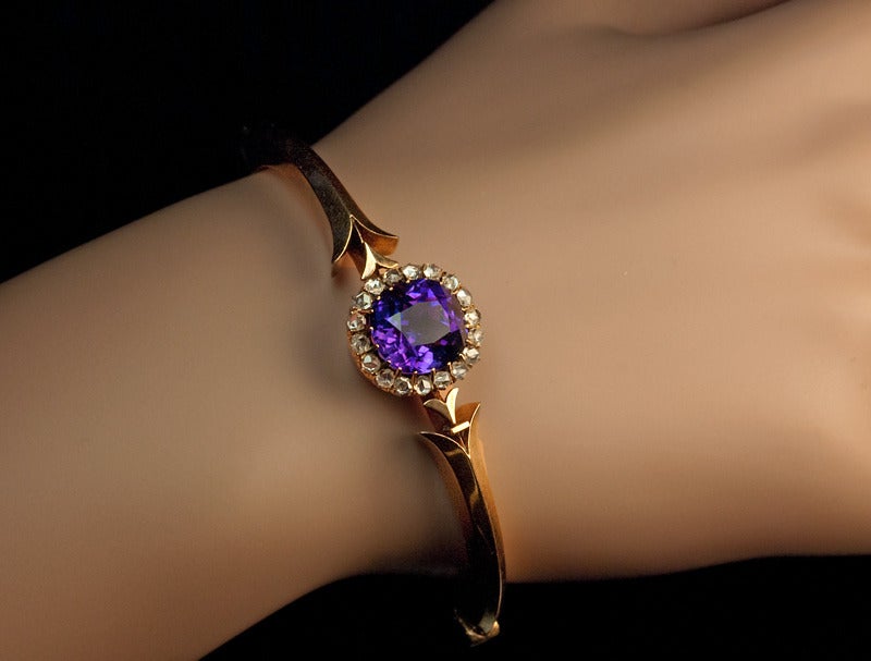Made in Moscow between 1882 and 1898

A 14K rose gold bangle bracelet is centered with a faceted Siberian amethyst surrounded by 18 rose cut diamonds.

The amethyst is 11 x 10 x 7.8 mm, approximately 5 carats.

Inner circumference of the