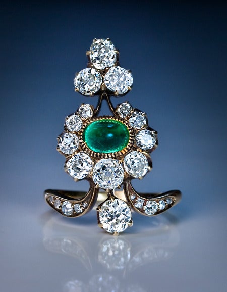 A Belle Epoque Antique Russian Diamond and Emerald Ring

circa 1890

This elaborately designed 19th century ring features a cabochon cut emerald (approximately 1 carat) and 23 old cut sparkling white diamonds (estimated combined weight 3 carats,