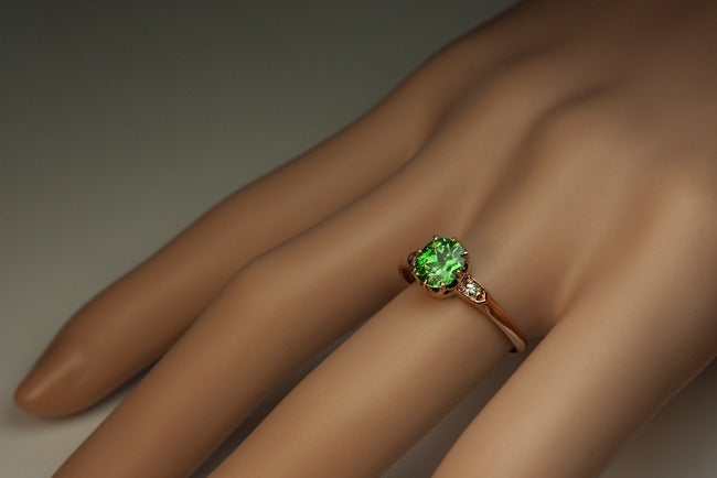 Made in Kiev between 1908 and 1917.

A 14K rose gold ring is set with a superb 1.08 ct Russian demantoid garnet accented by two brilliant diamonds. 

US ring size 7 1/4  (17 mm)

The demantoid displays an impressive fire across the stone and