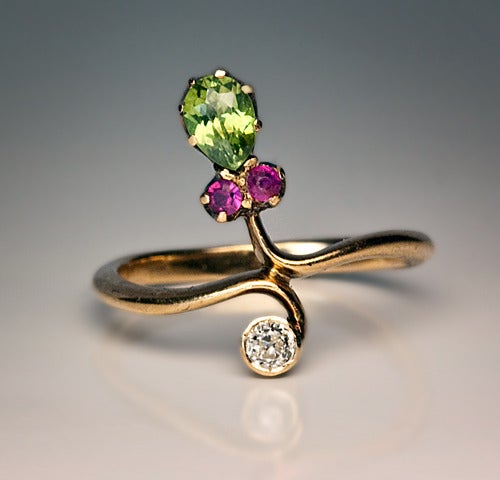 made in St Petersburg between 1899 and 1904

 A 14K gold ring is set with a drop shaped sparkling green demantoid garnet (5.8 x 3.9 x 2.6 mm, approximately 0.41 ct), two rubies and an old European cut diamond.

US ring size 6 1/2  (17 mm)

The