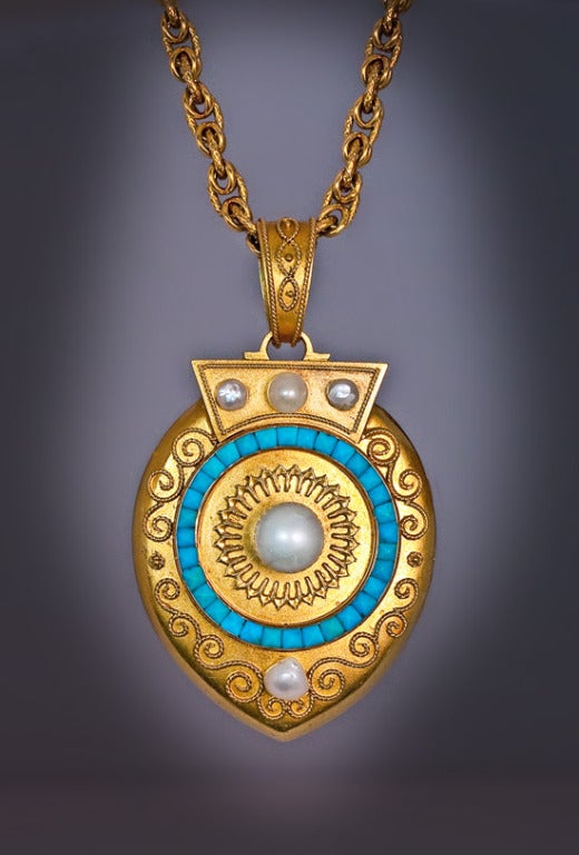 St. Petersburg, circa 1885

This superbly crafted large antique Russian gold locket is decorated with gold wire designs in the style of ancient Greek and Etruscan jewelry. 

The locket is centered with a large natural pearl (7.7 mm) surrounded