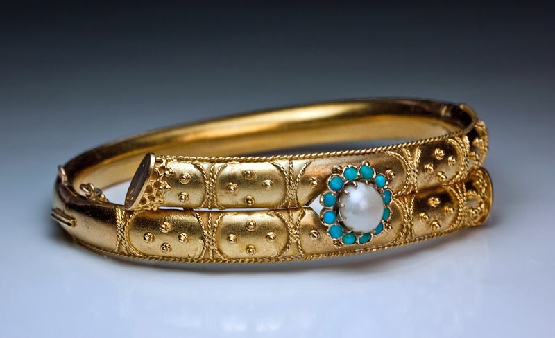 Victorian era 14K yellow gold bracelet with applied twisted gold wire decorations in ancient Etruscan style is set with a pearl surrounded by cabochon turquoise, marked on clasp with 56 zolotnik gold standard.

St. Petersburg c1885