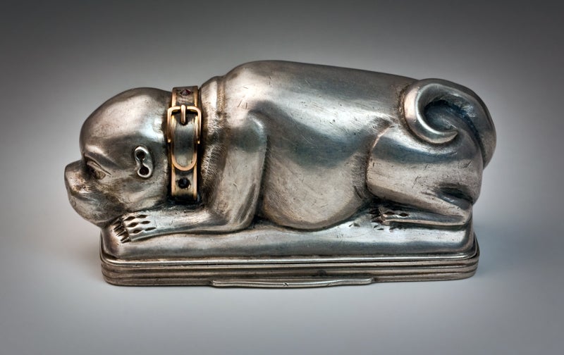 An antique 18th century Russian silver snuff box in the form of a pug dog, workmaster Alexei Ratjkov (a prominent Moscow silversmith, active 1777-1821). 

The eyes and gold trimmed collar are set with faceted garnets. 

A very finely modeled