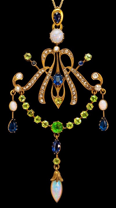 circa 1900

14K gold,  14 Russian Uralian demantoids, 6 sapphires, 4 opals, 44 rose-cut diamonds, and 5 diamonds in various cuts

The frame and loop are marked with later Russian (St Petersburg) control stamps from the 1930s for 583 gold