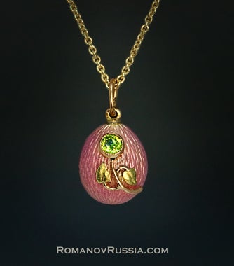 A delicate Art Nouveau egg pendant by Peter Carl Faberge.

The egg is covered with a fine soft pink translucent guilloche enamel.  

The front is applied with a rose and green gold Art Nouveau flower embellished with a faceted sparkling green