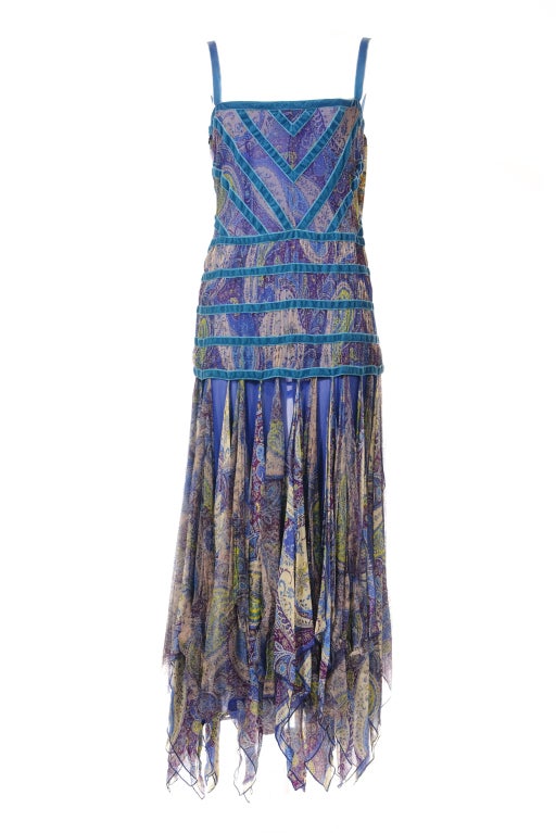 A lovely blue Etro paisley print floor length dress with peacock blue velveteen trimmings and fabulously fringed-hem. Side zipper close. Etro is always eclectic, colorful with strong artisanal traits. A style all of its own. Size 42