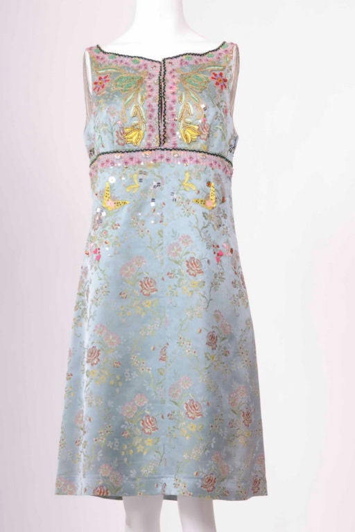 A  sleeveless and fitted multi-color brocade cocktail dress with embroidery and embellishment.  Hook & eye fastening on chest with zip fastening at side. 