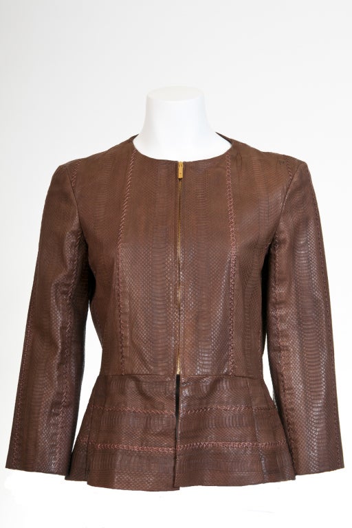 A brown 100% leather with stitches fitted jacket.  Nipped waistline and elegantly styled with delicate lace trimming.  Front zip closure.