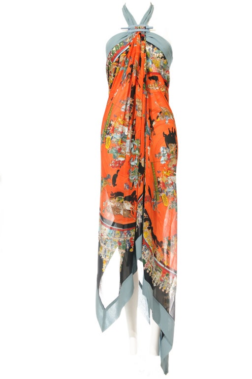 A beautiful silk halter neck dress with a very unique light-blue colored metal bolt at fron in typical Hermes scarf print and with asymmetric hem.