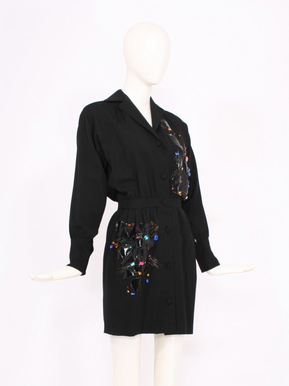 Black CHLOE dress by Karl Lagerfeld. The dress has colored jeweled stones and plastic reflective embellishments. Long sleeves and buttoned cuffs. Buttons opening at front of dress. Excellent condition. The hem has been altered to show more