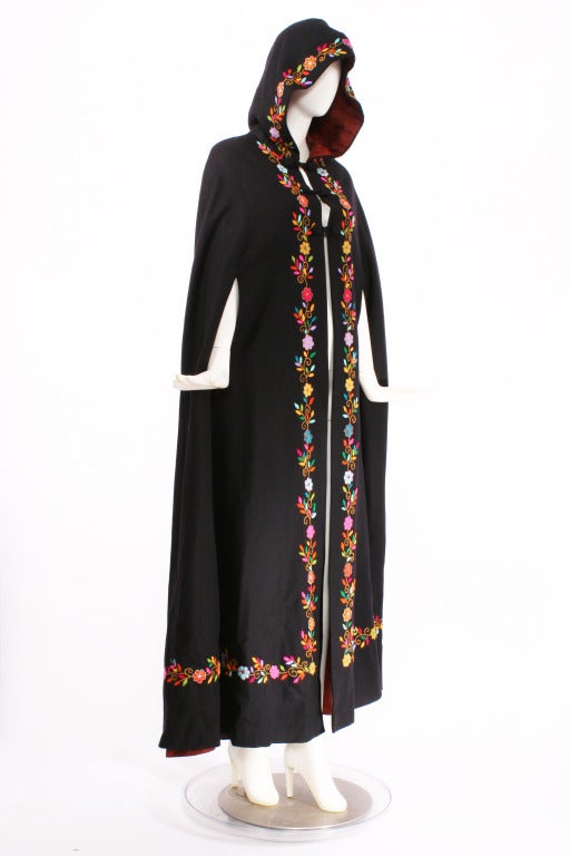 1970s Couture Embroidrered Cape with hood. This an exquisitely hand embroidered cape made from med-weight wool. Side slit opening for arms. Long, romantic and dramatic. Mint condition. Fits small to large. Shoulder to shoulder is 17