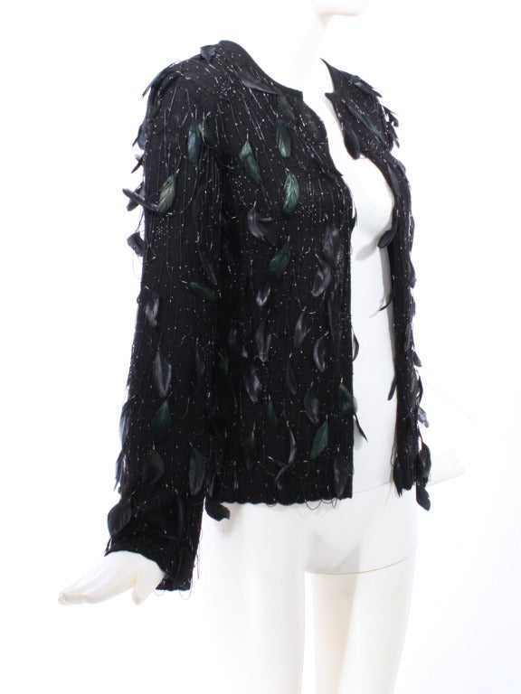 Incredible Oscar de la Renta Feathers and Beads Couture Jacket. 

Black cashmere sweater/jacket with attached iridescent feathers and festoon of beads. This is a stunning one of a kind garment perfect for the party season.

Store