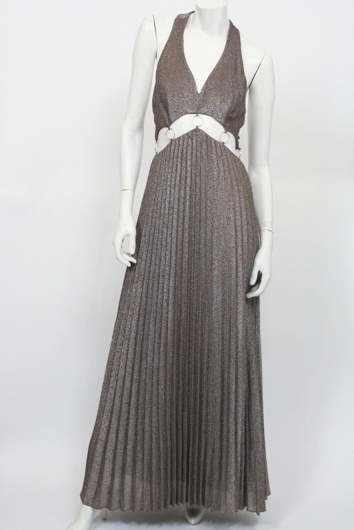 1970's Halston metallic cut-out maxi dress.  Pleated skirt. Cut out at waist. Embellished with silver rings. Halter top. Zips up the back. Cut-out back. Excellent condition.

STORE LOCATION
Devorado
436 E.9th St
NYC, NY 10009

Monday-Sunday