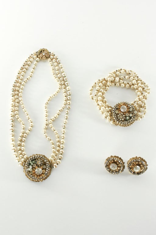 Stunning and elegant Miriam Haskell parure. Filigree back, imitation seed pearls, and rhinestones. Goldtone leaves and baroque pearls throughout. The necklace has three strands of pearls while the bracelet has five. Excellent condition.

Store