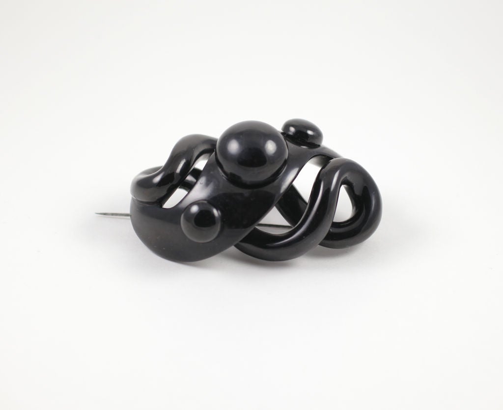 Whirls of jet undulate from back to front forming a grand and dramatic brooch of Whitby jet with an unexpected modern presence.  Jet spheres set into cut out circles make this 19th century creation look like a photo of the moon surface. The brooch