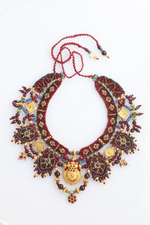 Abundant rubies, emeralds, lapis lazuli, garnets, gold beads and 22kt antique Kundan ornaments are woven in petit point into a necklace of hanging garlands. . The individual needlepoint stitches repeat ancient patterns of the Kundan culture. Colors