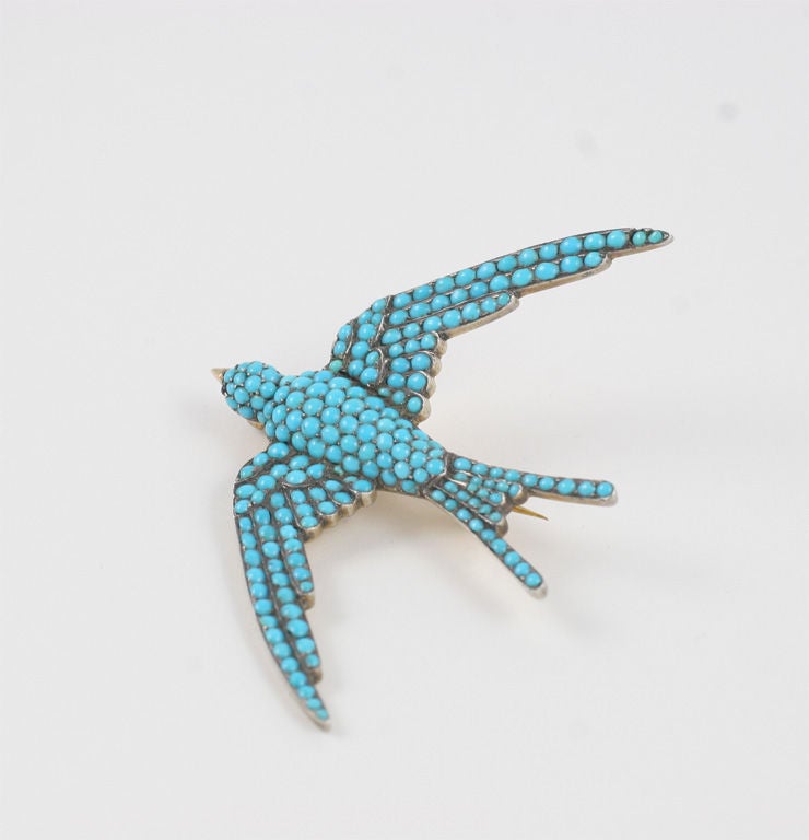 An 18kt setting holds natural pave turquoise stones shoulder to shoulder in this mid 19th century swallow brooch. The French conquered this stone setting technique and used it with precious gems in brooches and rings. The swallow's wings glide