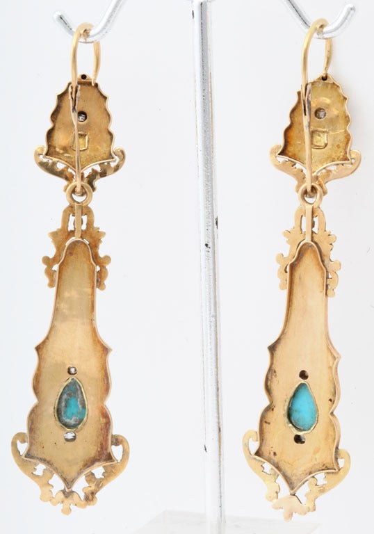 A pair of chandelier earrings that are exotic, extremely French, and romantic.  The form has French fanfare with curves and swirls in all directions. Persian turquoise of natural color plays perfectly against the black enamel background. Small