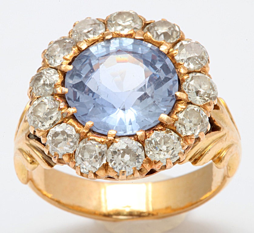 A ring that stuns, A heavenly blue gem framed with stars of flickering diamond . The blue gem, 4.35 cts, is a natural cornflower blue sapphire, a rich, medium blue color with a touch of lavender in the mix. It is rare to find a sapphire that is not