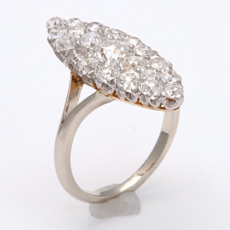 An especially brilliant cluster of white old mine diamonds sets this ring apart from the others of this style, The diamond weight is approximately 1 ct. Set in a marquise shape, the diamonds are a tribute to the glitter of the Edwardian era. Closely