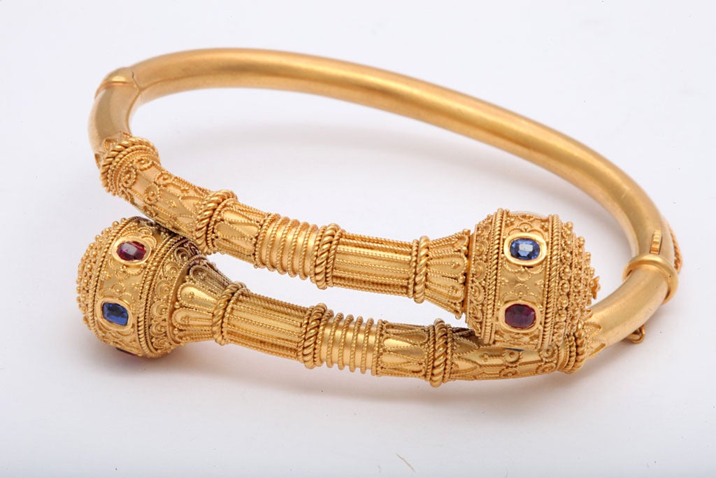 No stops barred from the superb granulated gold details of this etruscan revival bracelet. The stones of saturated color, are set amidst the textured surface of the bangle. Like a museum piece from early Etruscan times, the granulation varies in