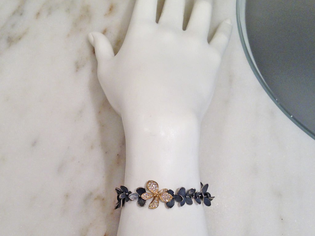 Hydrangea Bracelet handmade in oxidized sterling silver with one 18k yellow gold flower set with round, brilliant-cut white diamonds.