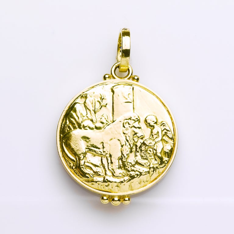 This stunning reversible coin pendant is intricately hand carved in Lapis Lazuli. It is a replica of a 15th century Duke of Milan coin showing Cupid, God of love, teaching the lion to sing. The  reversible side shows the same scene in 18 karat