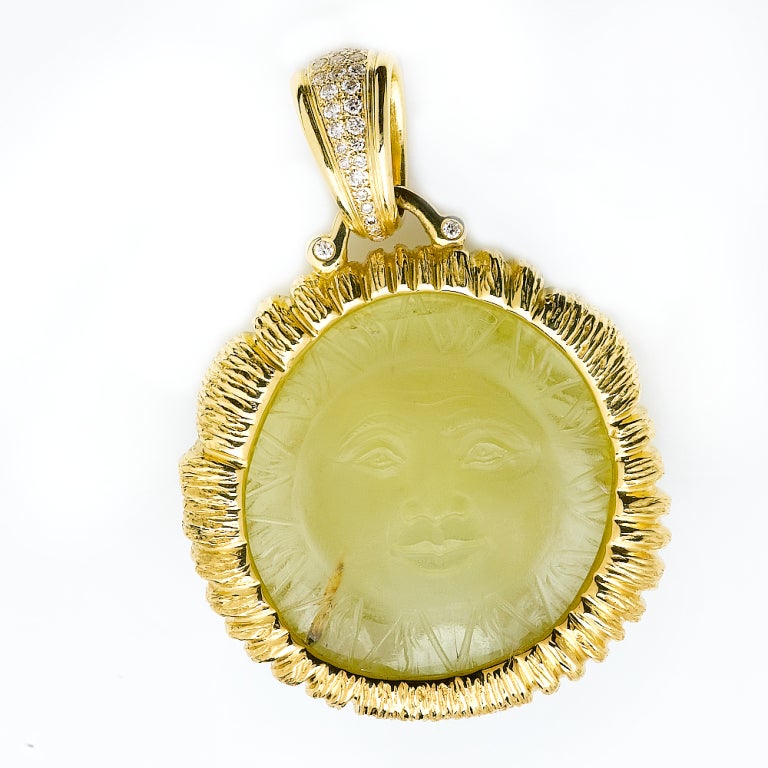 Stunning hand carved citrine pendant. Carved in exquisite detail by renowned Idar-Oberstein carver with the face of a lion on one side and the other with the face of the sun. Cast in 18 karat gold surround with pave diamond bail.