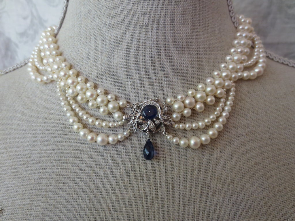 This decadent pearl necklace lays perfectly on the collar of any neckline. It features large 5-6 mm woven pearls and is finished with a unique vintage 18k white gold clasp centerpiece where the designer Marina J has added sapphire bead and a faceted