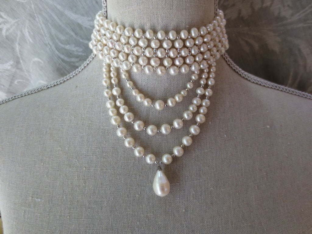 This stylish choker features 5 - 7 mm pearls beautifully woven with faceted sterling silver beads and is finished with elegant graduated pearl drape centerpiece. This choker would look perfect on a tall and slender neckline and is 12.5 inches long.