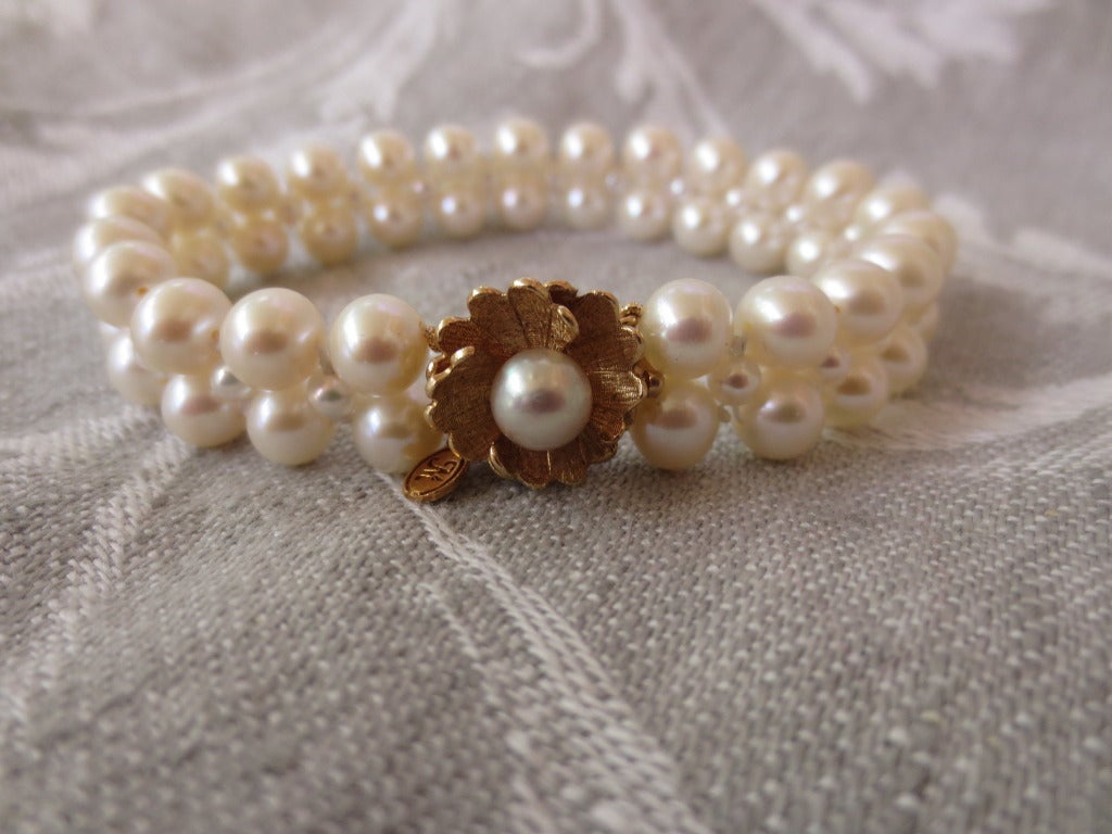 Unique and elegant, this bracelet's clasp also serves as a dramatic centerpiece. The vintage floral centerpiece clasp is made of 14k gold with cultured pearl center. Bracelet measures 7 inch and is made of fine 6mm and 3mm cultured pearls.
