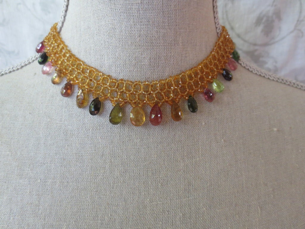 This hand woven citrine necklace with mutli-color tourmaline drops and 14k yellow gold clasp has a delicate lace-like design that perfectly tapered to fit the curves of the neckline. At 16 inches the woven necklace lays perfectly on the necklace.