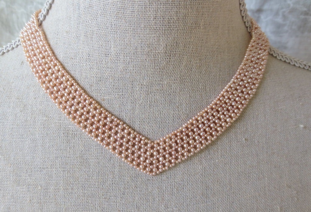 This beautiful V-shaped woven pink pearl necklace is multi-stranded with a 14k yellow gold clasp. The pearls are a beautiful blushing pink tone, giving the necklace a graceful look. This day or evening piece is elegant on its own or can be accented