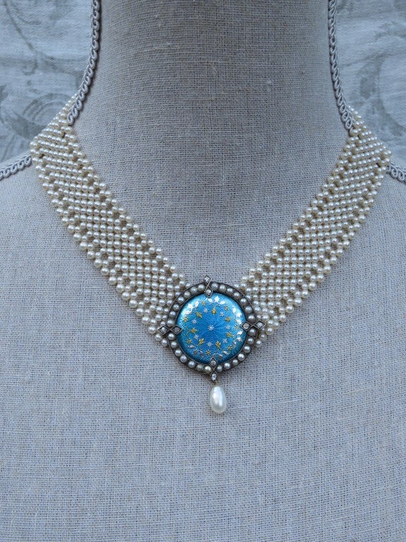 This unique centerpiece is reminiscent of the high-quality craftsmanship of a bygone era. Made with blue enamel, diamonds, and pearls the centerpiece, originally the cover of an antique pocket watch, shimmers beautifully. In perfect condition with